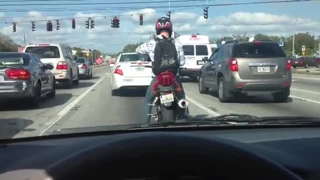 Моторист се раздвижва с попинг докато чака на червен светофар