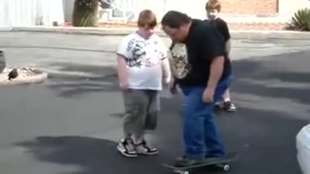 Баща показва на сина си как се кара скейтборд