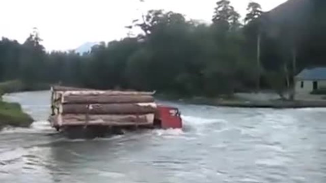 Камион пълен с дърва преминава през трудно препятствие