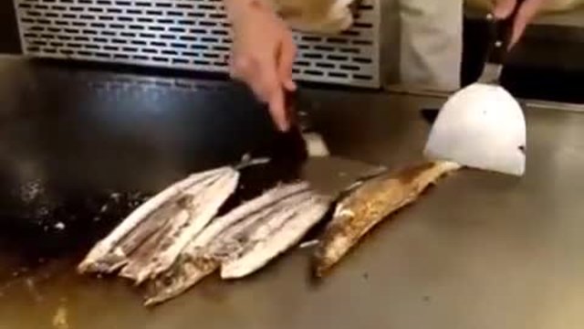 Китайски готвач виртуоз в печенето на риба пред клиенти