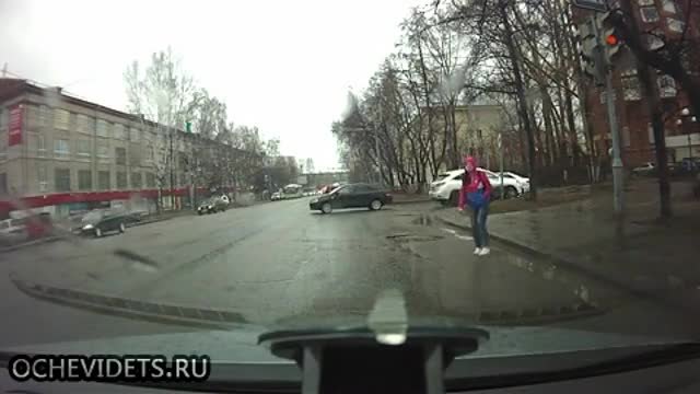 Момиче предпазливо пресича въпреки наличието на светофар