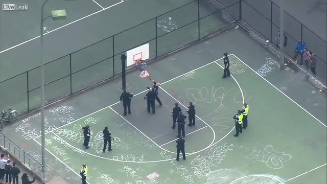 Полицаи опитват да свалят мъж от баскетболен кош