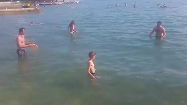 Момчета  играят фризби на плажа (видео)